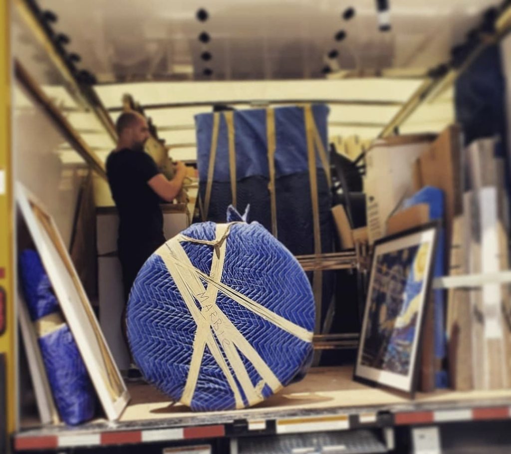 House movers carrying furniture into a moving truck